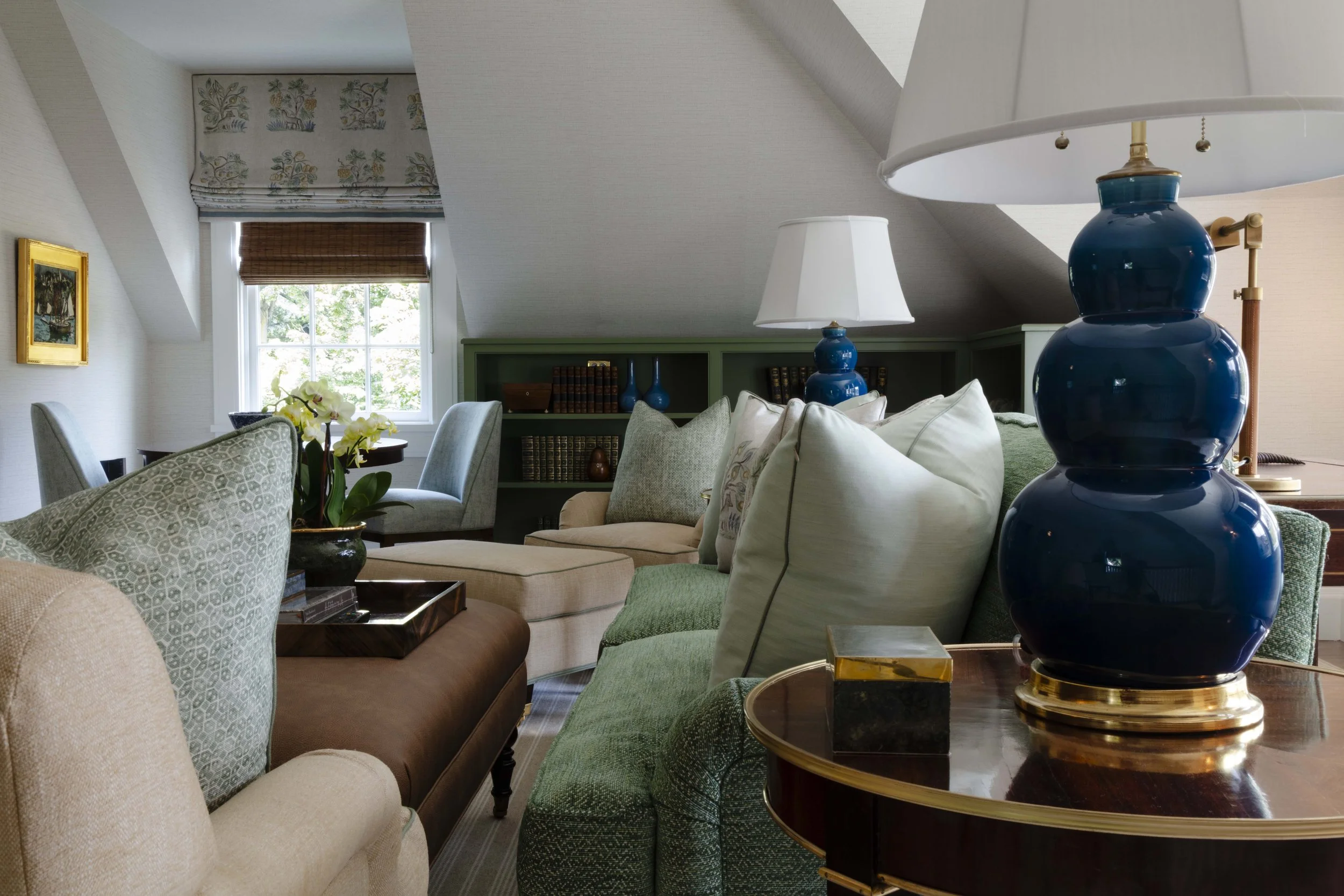 Sitting area with blue ceramic lamp and bookshelf