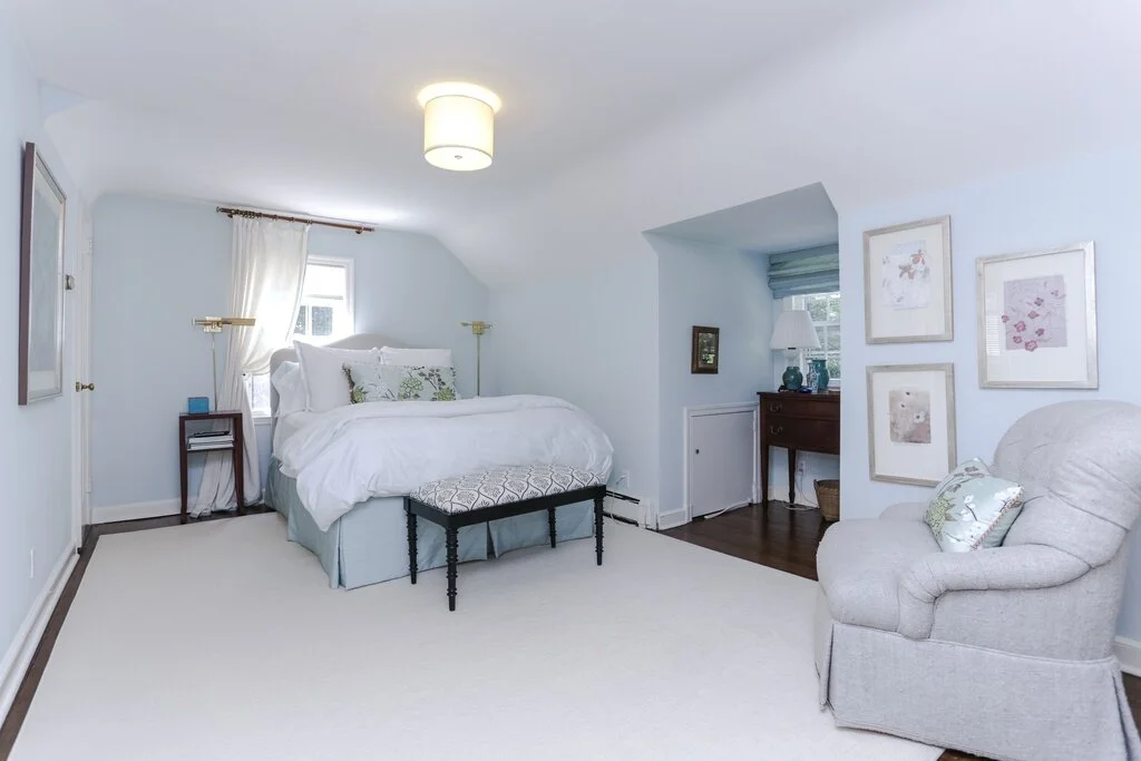 Cozy bedroom with light blue walls and white bedding