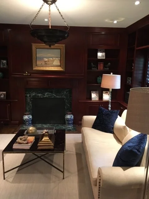Living room with fireplace, wood panelling and glass coffee table