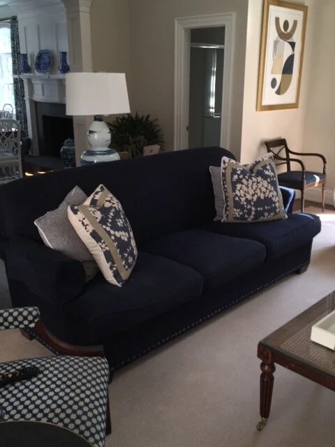 Navy blue sofa with decorative pillows and abstract artwork