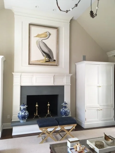 White fireplace with pelican painting and blue-and-white vases