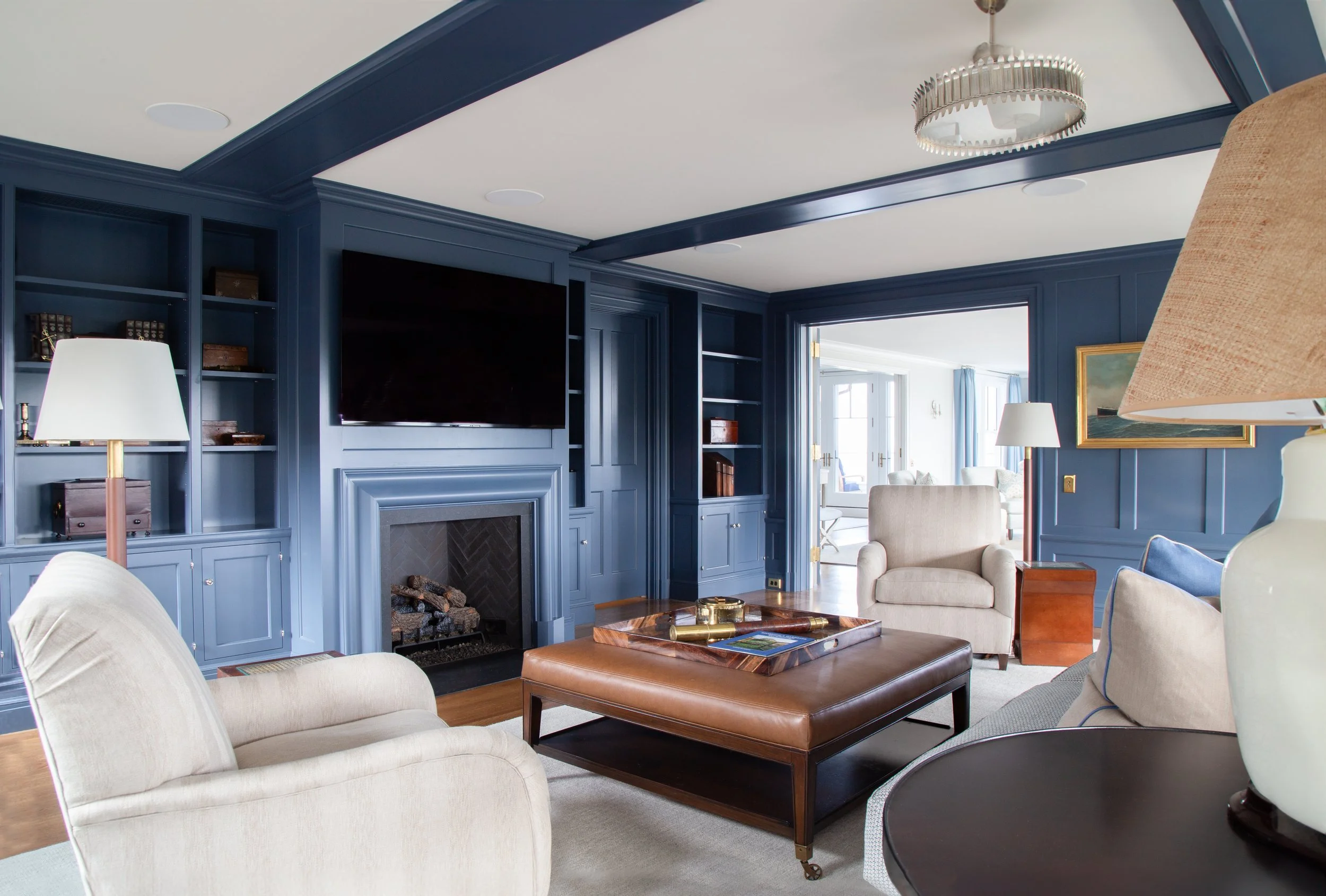 Blue built-in bookshelves with fireplace and armchairs